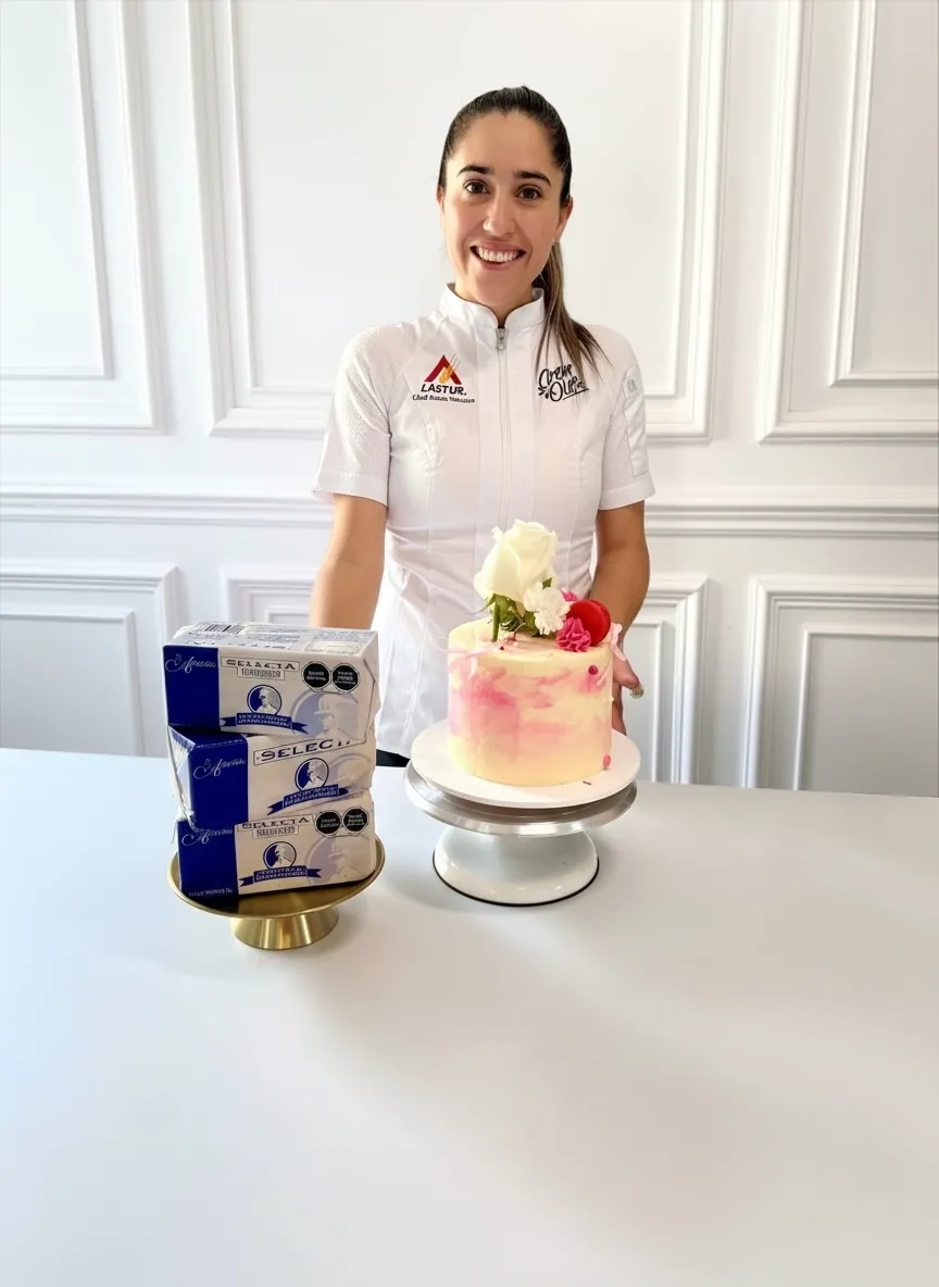 Laura Saturno con un pastel de dos pisos en azul marino y rosa sobre base dorada