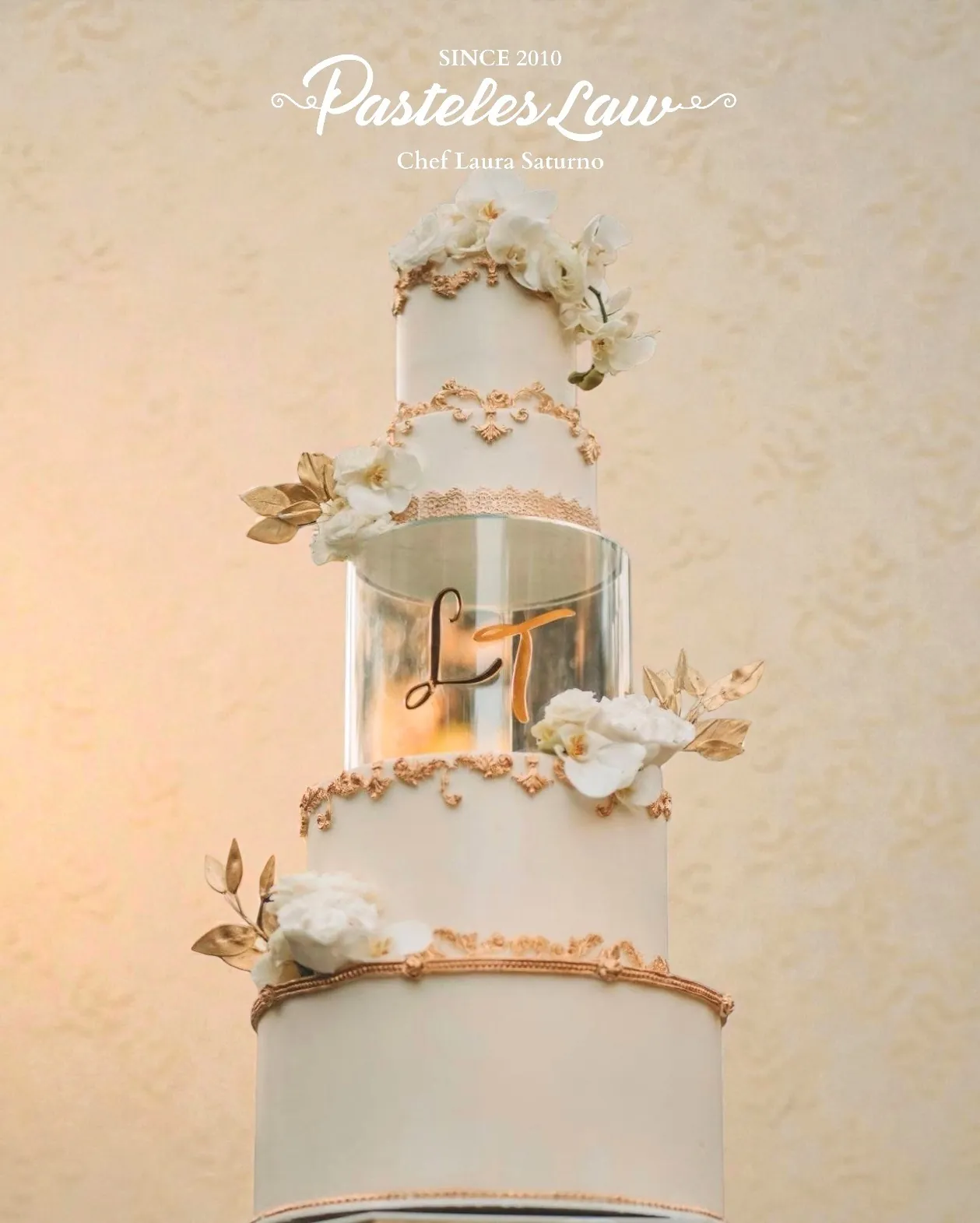 Pastel de bodas de cuatro pisos en blanco con hojas doradas y flores de azúcar